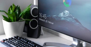 black Logitech G710+ wireless keyboard and wireless mouse near gray flat screen computer monitor on table